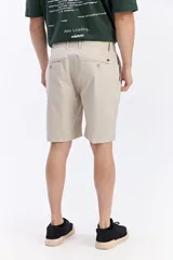 Bermuda china de corte clásico y color beige, con cintura fija y bolsillos laterales y traseros con botón.