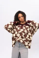 Buzo de tejido de punto con diseño estampado geométrico retro, cuello tipo polo con cierre frontal de botones y mangas largas con puños acanalados en color bordó.