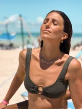 Top de bikini color verde militar brillante, con escote cuadrado y tirantes anchos. Presenta una argolla decorativa de madera en el centro del busto y se ata en la espalda.