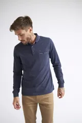 Remera polo de manga larga para hombre, confeccionada en algodón. Presenta un diseño de ajuste regular, con cuello clásico, cierre frontal con botones, bolsillo delantero con botón y logo bordado.