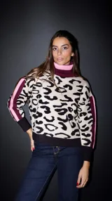 Sweater de punto con estampado animal print, cuello alto tipo polera en combinación de colores rosa y bordó, y detalles de franjas laterales en las mangas.