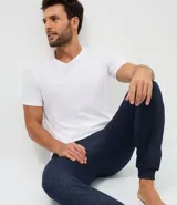 Pantalón de pijama tipo jogger color azul marino, con cintura elástica y cordón de ajuste. Presenta puños elásticos en los tobillos y un acabado jaspeado.