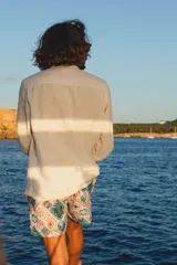 Short de baño con estampado geométrico en tonos turquesa, naranja y beige. Cuenta con cintura elástica, dos bolsillos laterales, un bolsillo trasero y red interior hipoalergénica.