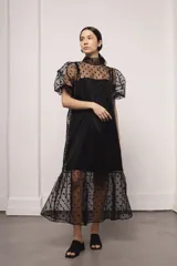 Vestido largo color ocre con estampado de cuadrados dorados, cuello alto y corte amplio. Incluye viso liso al tono.