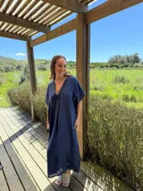 Vestido largo de lino color azul marino, con escote en V y mangas cortas amplias. Presenta un corte relajado y bolsillos laterales.