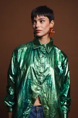 Camisa de popelina verde metalizada, de corte holgado y relajado, con mangas largas y cierre frontal con botones.