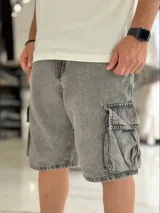 Bermuda cargo de denim color gris con efecto acid wash, corte baggy oversize y bolsillos laterales con solapa.