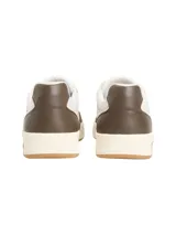 Zapatillas deportivas de corte bajo, color block blanco y marrón oscuro, con cordones. Presentan una suela cupsole de goma color crema y marrón claro, y un parche con el logo de Tommy Jeans en el lateral.