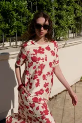 Vestido midi de manga corta, con diseño holgado, cuello redondo y estampado abstracto con detalles florales en tonos marrones y violetas.