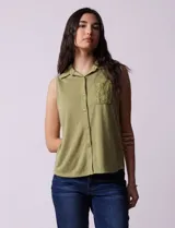 Blusa color crema sin mangas, con cuello camisero, cierre frontal con botones y bolsillo de crochet.