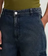 Bermuda de hombre en denim de algodón, modelo cargo, corte baggy y tiro medio. Presenta bolsillos laterales tipo cargo y cierre tradicional con botón y cremallera.