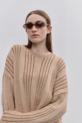 Sweater de punto color gris con diseño de rayas verticales oscuras, cuello redondo y calce relajado de mangas largas.
