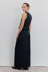 Pantalón de vestir de corte wide leg, color negro, con tiro alto y diseño de pinzas frontales. Presenta una caída fluida y holgada.