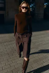 Bermuda larga color marrón oscuro, tiro medio, con pinzas frontales y cinturón de textura animal print plateado.