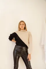 Buzo de lana de cordero italiano color beige y negro, con cuello cisne y corte holgado.