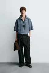 Camisa polo de calce relajado confeccionada en tejido de lino color azul. Presenta cuello solapa con abertura frontal en V y manga corta.