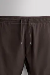 Pantalones cortos de entrenamiento 2 en 1 de color marrón, confeccionados por Zara Athleticz en tejido técnico ligero y elástico con malla interior. Cuenta con cintura elástica ajustable con cordón y bolsillos laterales.
