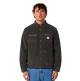 Campera de pana color negro, con cierre de botones a presión, cuello camisero, mangas largas y dos bolsillos frontales en el pecho con cierre de cremallera. Incluye una pequeña etiqueta con el logo de la marca.