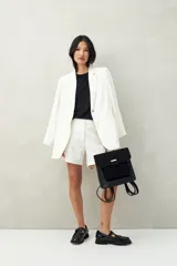 Bermuda sastrera color blanco con finas rayas verticales, de tiro alto y corte a la rodilla.