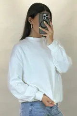 Buzo de cuello redondo, corte oversize, con mangas largas y puños elásticos.