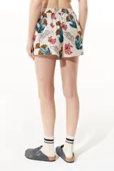 Short de lino estampado con flores y aves. Cuenta con calce holgado, elástico en cintura trasera y bolsillos laterales.