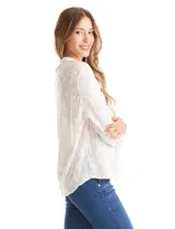 Blusa de algodón con diseño de broderie floral, cuello a la base, cierre frontal con botones y mangas largas amplias.