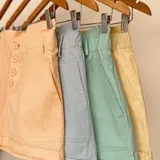 Short color amarillo pastel con cintura elastizada y detalle de botones frontales.