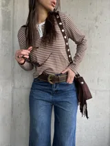 Remera de manga larga a rayas horizontales en tono tostado y blanco, con cuello redondo y cartera de botones frontal.