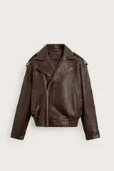 Cazadora biker oversize de piel color marrón, con cuello de solapas de pico, cierre frontal asimétrico con cremallera, bolsillos laterales de vivo y bajo con elástico.