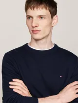 Sweater de punto fino en color azul marino, confeccionado en una mezcla de algodón pima orgánico y cachemira. Presenta un diseño de cuello redondo, con terminaciones de punto canalé en cuello, puños y bajo. Incluye el logo de la marca Tommy Hilfiger bordado en el pecho.
