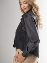 Camisa blanca de manga larga con bordado de encaje en el frente y mangas semi abullonadas.