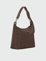Cartera tipo hobo de tamaño grande, confeccionada en cuero vacuno suave, con correa ajustable y cierre superior con solapa y botón a presión.