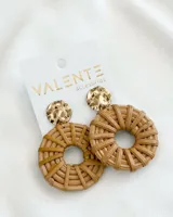 Aros colgantes con base dorada circular y dije circular de mimbre color beige.