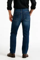 Pantalón jean negro de corte skinny y tiro bajo, con diseño clásico de cinco bolsillos y cierre frontal con botón y cremallera.