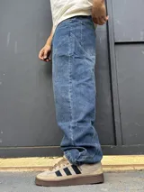 Pantalón de denim azul con diseño balloon y costuras curvas decorativas en las piernas.