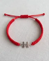 Pulsera de hilo rojo trenzado en macramé, con dije central de plata 925 con diseño de dos nenas tomadas de la mano y cierre regulable.