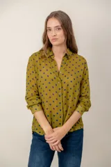 Camisa de manga larga con estampado de leopardo, cuello clásico y cierre frontal de botones. Presenta un corte holgado y puños abotonados.