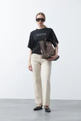 Remera blanca de manga corta con bordado frontal en azul que dice "dolce far niente the sweetness of doing nothing". Tiene un calce relajado.