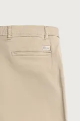 Pantalón chino skinny fit color gris oscuro, confeccionado en mezcla de algodón con elasticidad. Cuenta con bolsillos frontales, bolsillos traseros de vivo y cierre frontal con cremallera y botón.