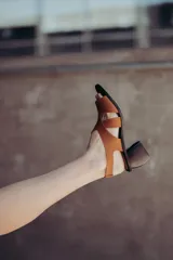 Sandalias de neopreno color marrón con tiras cruzadas en el empeine y puntera abierta. Cuentan con un taco irregular de 6 cm de altura y plantilla de cuero.