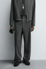 Pantalón regular fit color marrón oscuro, confeccionado en tejido con viscosa. Cuenta con cintura elástica, bolsillos delanteros y detalle de bolsillos traseros de vivo. El cierre frontal es con cremallera y botón.