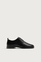 Zapato de vestir tipo derby fabricado en piel, con forro interior y plantilla de piel. Presenta horma cuadrada y suela con ligero tacón.