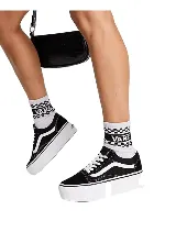 Championes Vans modelo UA Old Skool Stackform, de color negro con la clásica franja lateral blanca y suela de plataforma alta en color blanco.