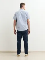 Camisa de manga corta con cuello abotonado y estampado a rayas verticales color beige y blanco.