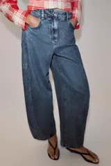Jeans balloon leg de tiro medio y longitud al tobillo, con efecto lavado, cintura con trabillas, cinco bolsillos y cierre frontal con cremallera y botón.
