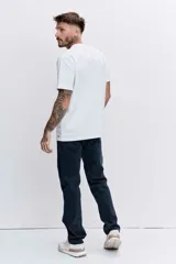 Pantalón de jean corte regular, color azul oscuro, con cierre de botón y cremallera, y bolsillos laterales y traseros.