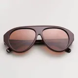 Lentes de sol con armazón grueso de acetato color marrón oscuro y diseño tipo aviador con puente superior plano. Lentes polarizados con protección UV400 y tono marrón degradé.