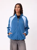 Campera de polar marca Rusty, color azul con paneles laterales en celeste claro. Presenta cierre frontal completo, cuello alto y logo de la marca bordado en el pecho.