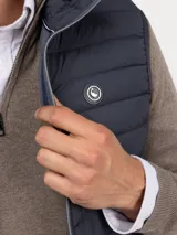 Chaleco acolchado de hombre confeccionado en nylon reciclado, con cierre frontal de cremallera, sisas elásticas y bolsillos laterales con cierre.