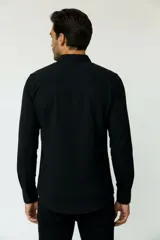 Camisa de poliéster color marrón, de corte holgado, con mangas largas, cuello camisero clásico y cierre frontal de botones.